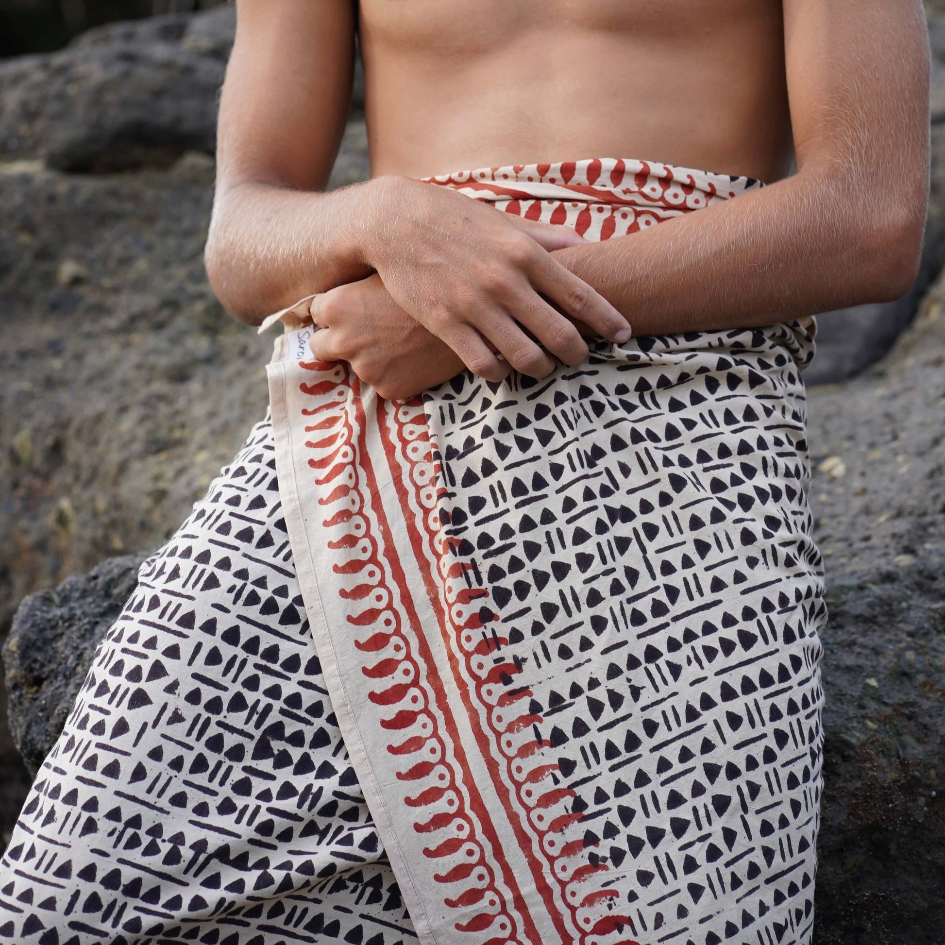 Man wearing black, brown, and ochre Batik Cotton Mens Sarong from Sarong Hut Australia — lightweight, breathable, ethical travel wrap.
