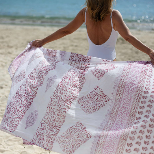 Freedom pink xl cotton sarong styled on beach model wearing sarong hut design