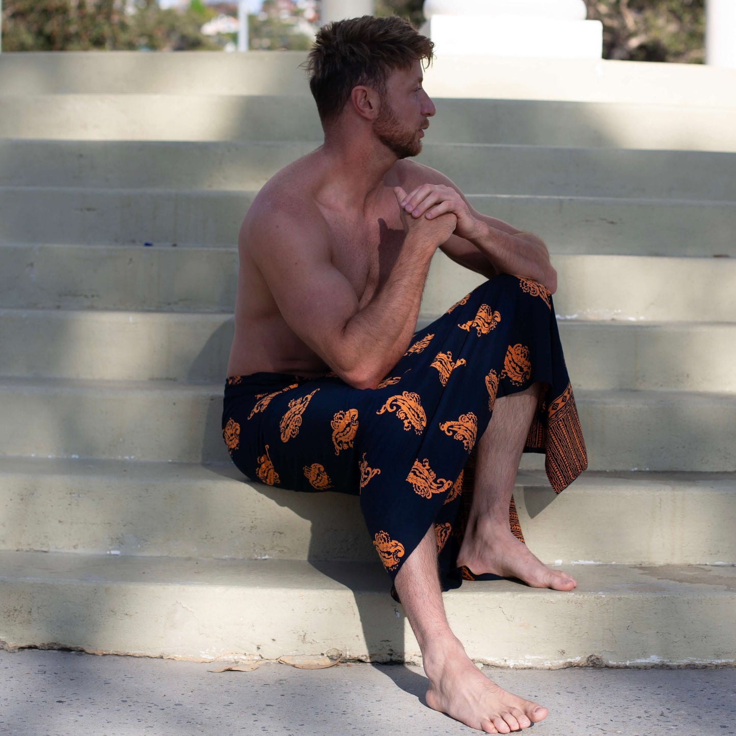 Manly luxe sarong styled on beach model wearing sarong hut design