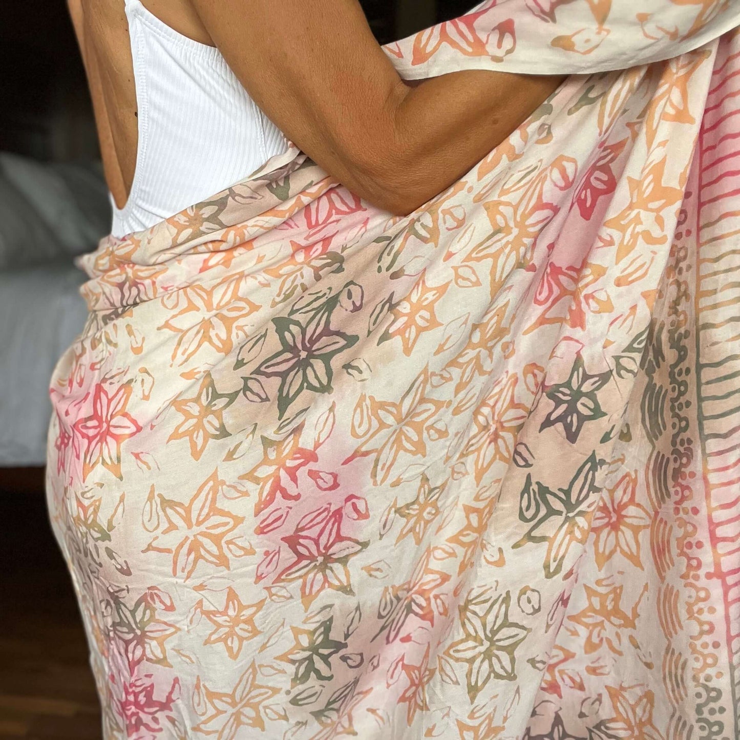 Pareo cream luxe sarong styled on beach model wearing sarong hut design