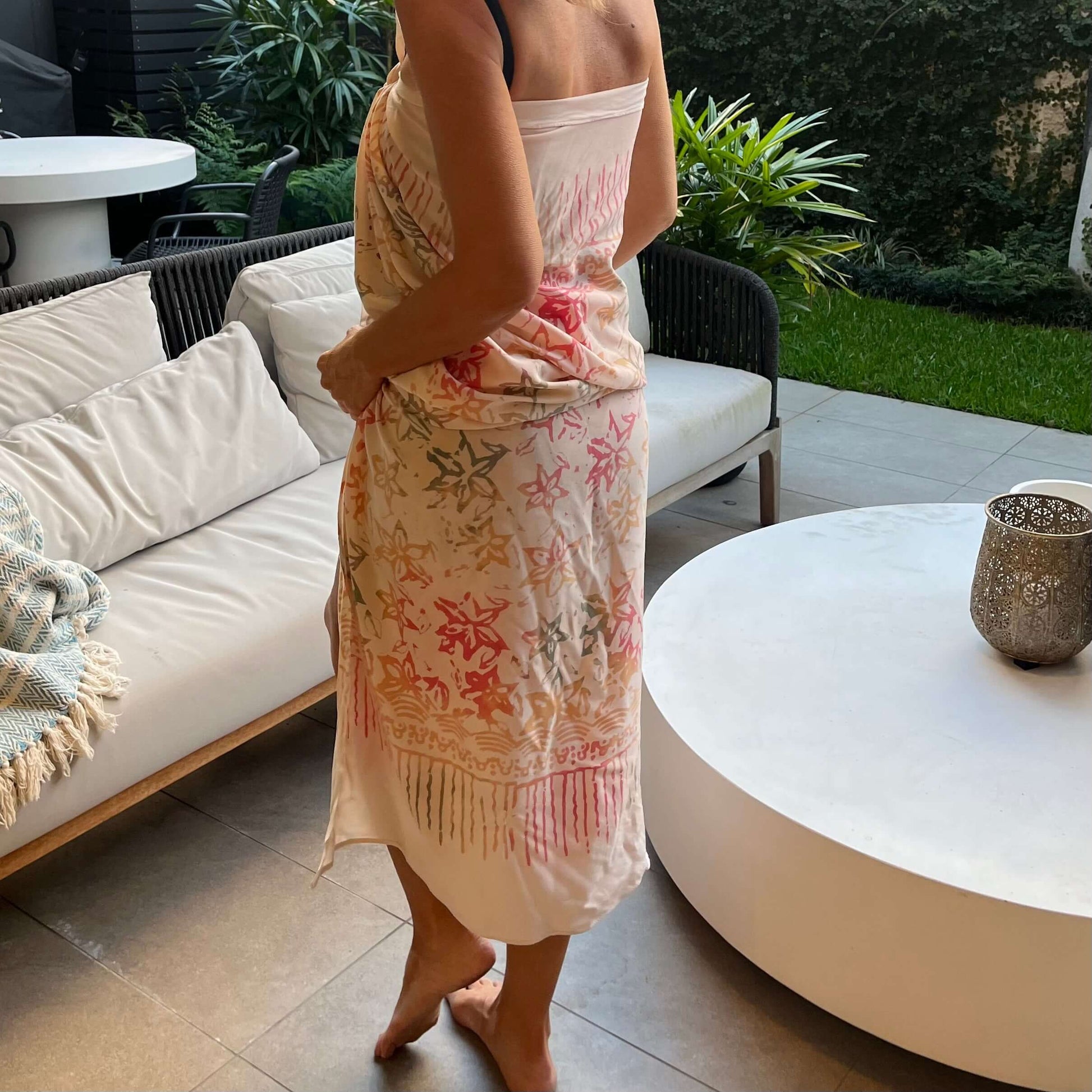 Pareo cream luxe sarong styled on beach model wearing sarong hut design