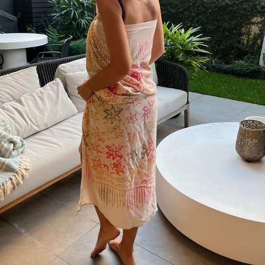 Pareo cream luxe sarong styled on beach model wearing sarong hut design