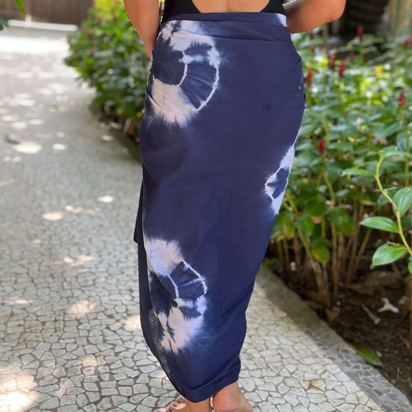 Reef cotton sarong styled on beach model wearing sarong hut design