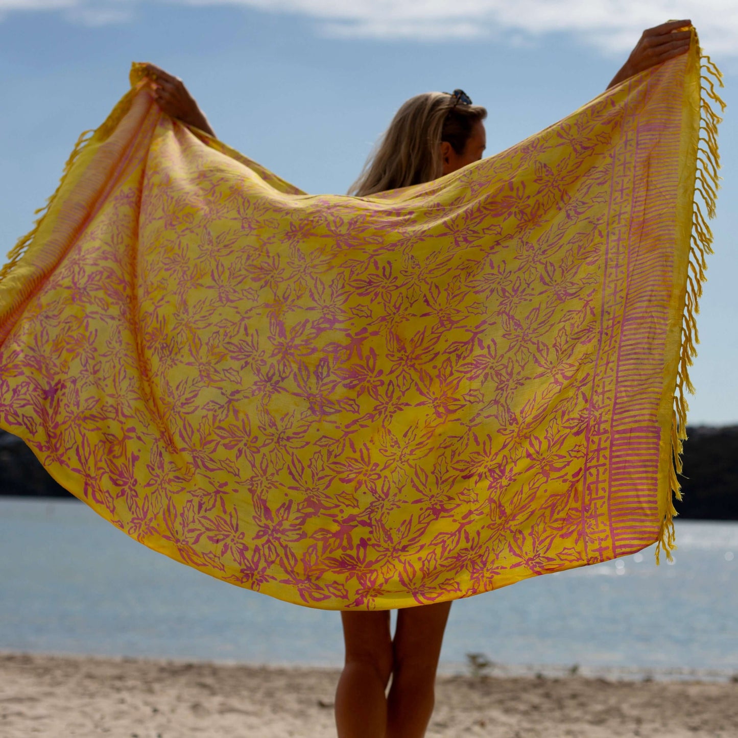 Relaxed beach sarong styled on beach model wearing sarong hut design