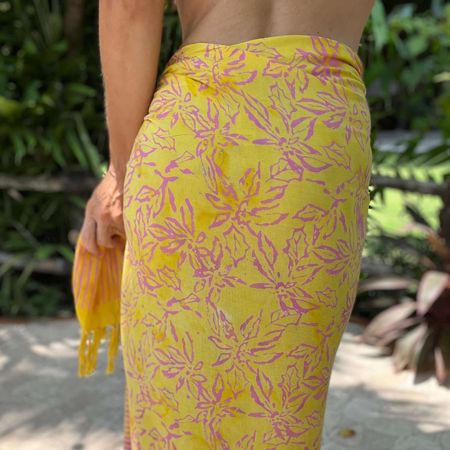 Relaxed beach sarong styled on beach model wearing sarong hut design