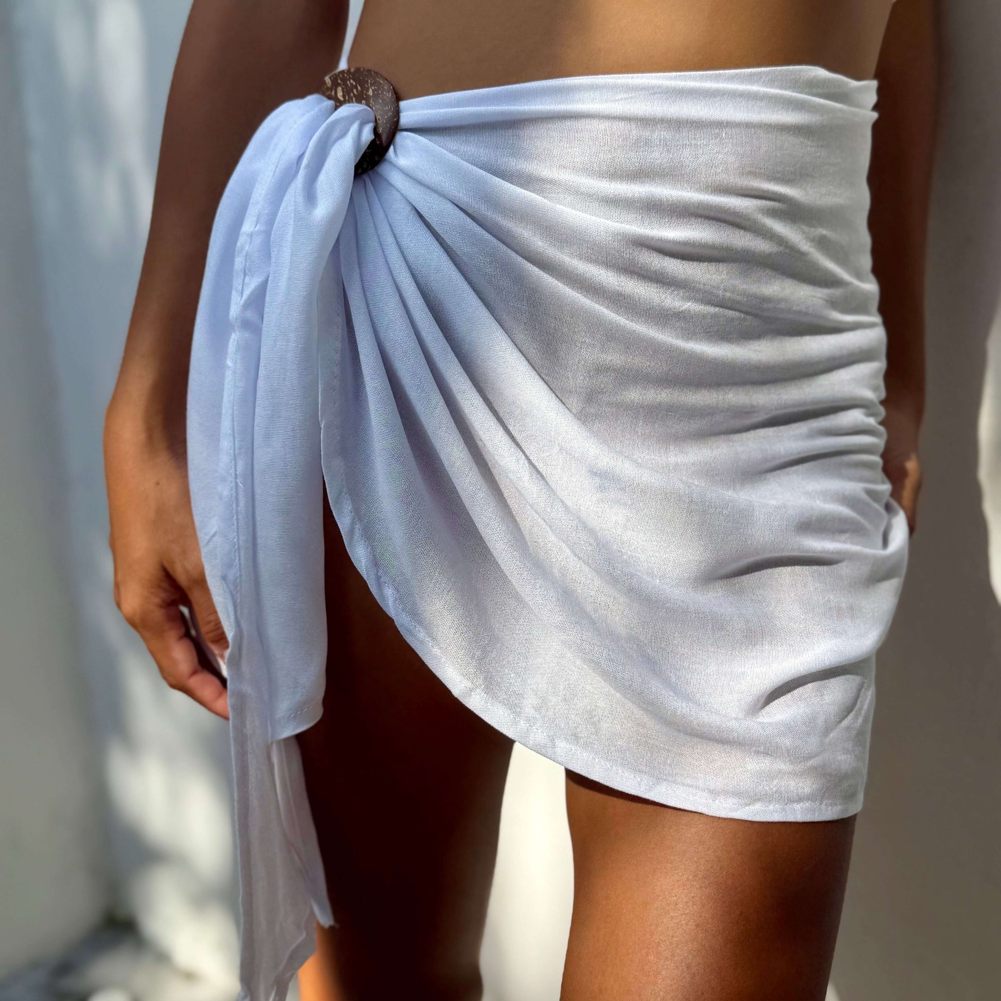 Mini sarong white beachwear look, photographed outdoors in natural light