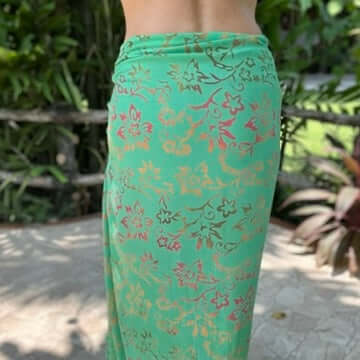 Body wrap beach sarong from behind model wearing sarong hut design