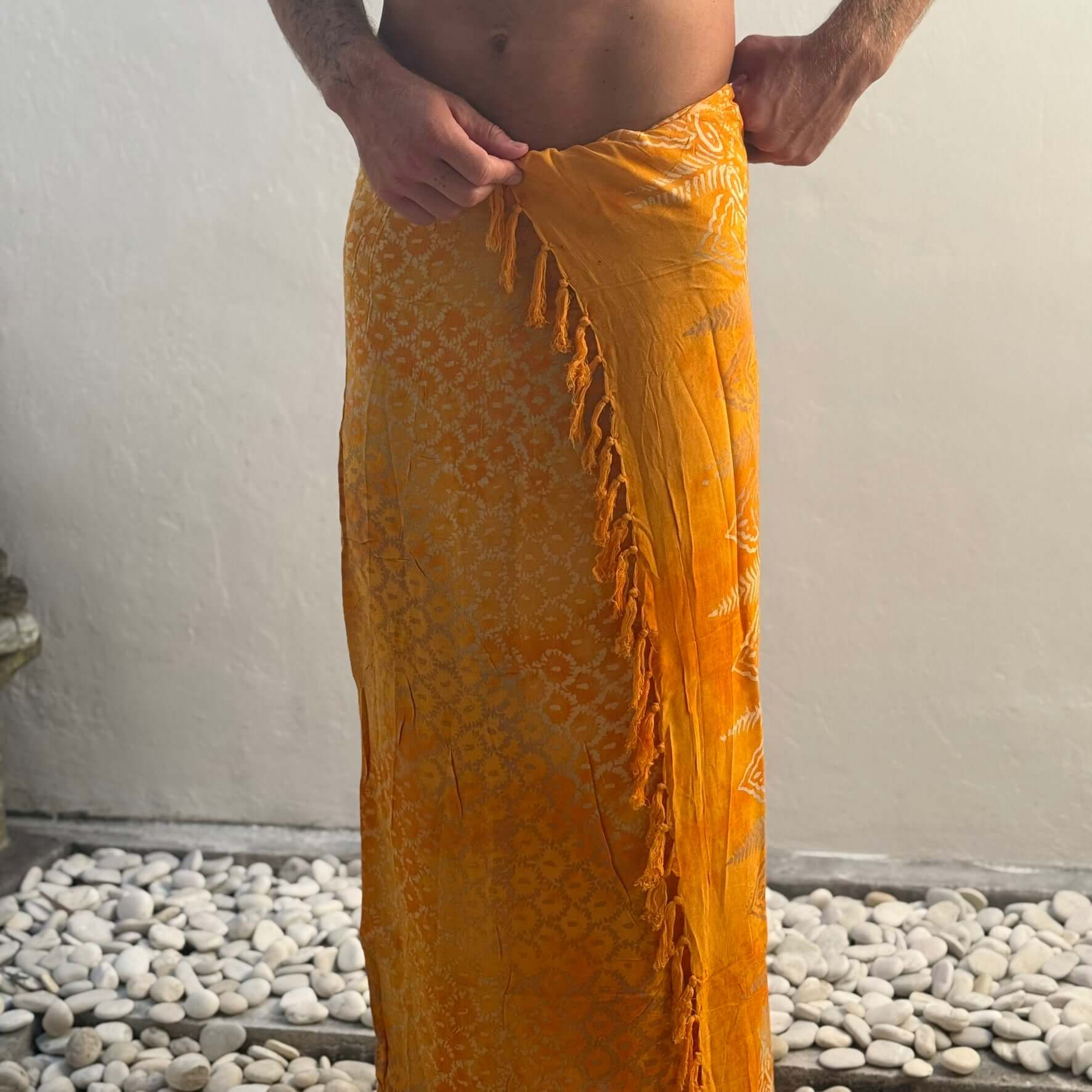 Vibrance Saffron Mens Beach Sarong man adjusting tassels
