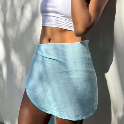 Mini sarong aqua beachwear look, photographed outdoors in natural light