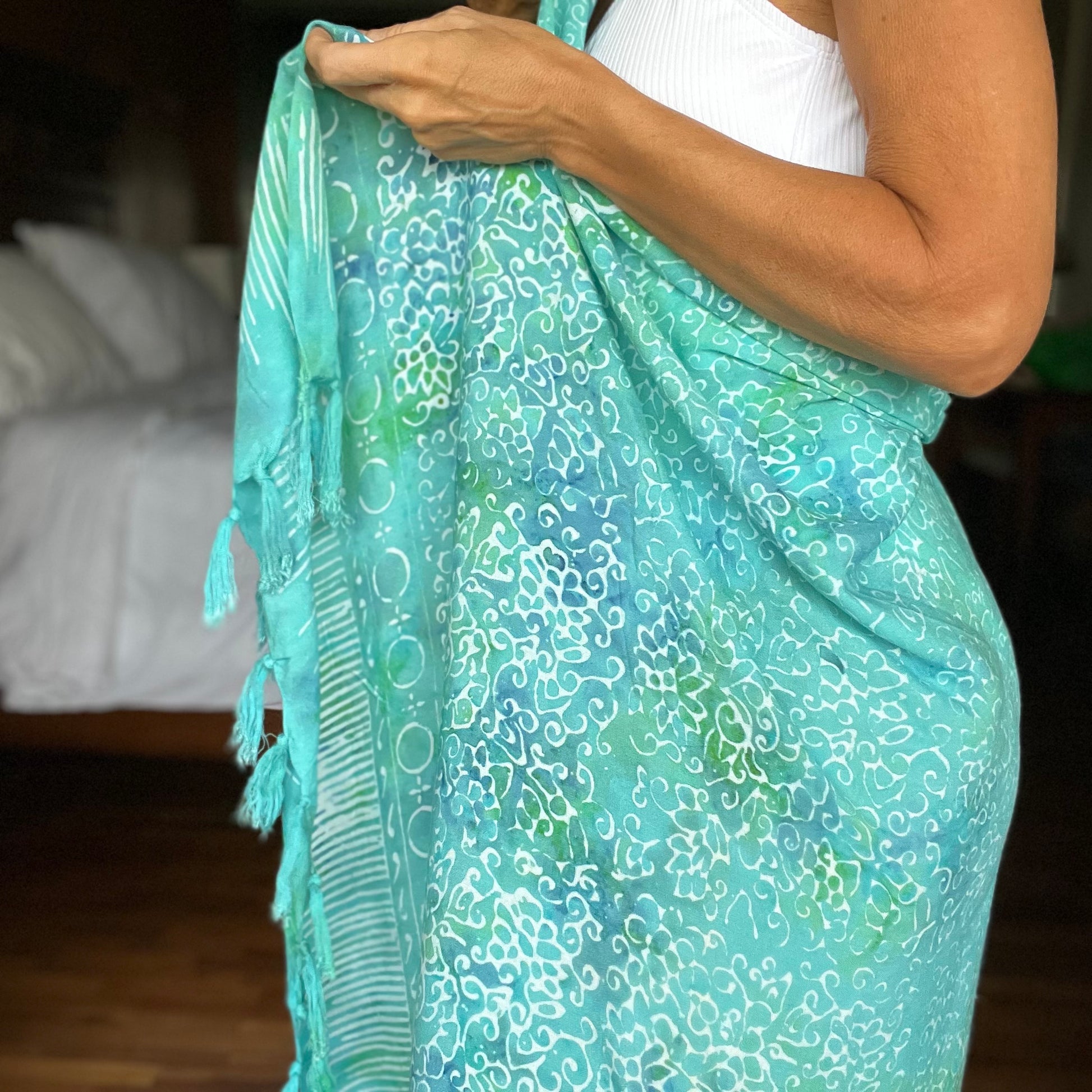 Free spirit aqua beach sarong styled on beach model wearing sarong hut design
