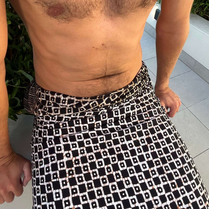 Tarzan men luxe sarong sarong tied at hip, lightweight rayon by sarong hut. Men's body shot up close of the batik pattern. Black and bronze colors.