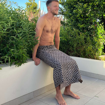 Tarzan men luxe sarong beachwear look, photographed outdoors in natural light