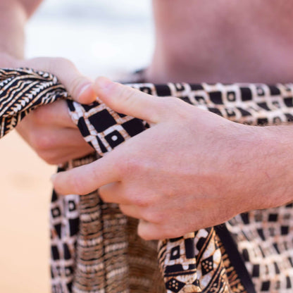 Tarzan men luxe sarong beachwear look, photographed outdoors in natural light