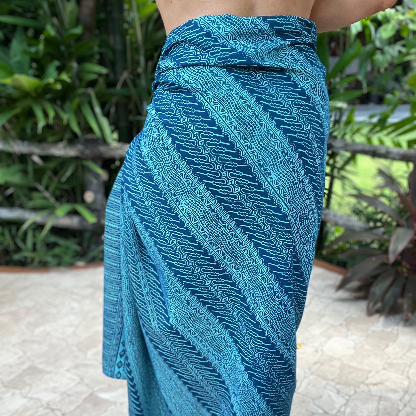 Vivid luxe sarong styled on beach model wearing sarong hut design
