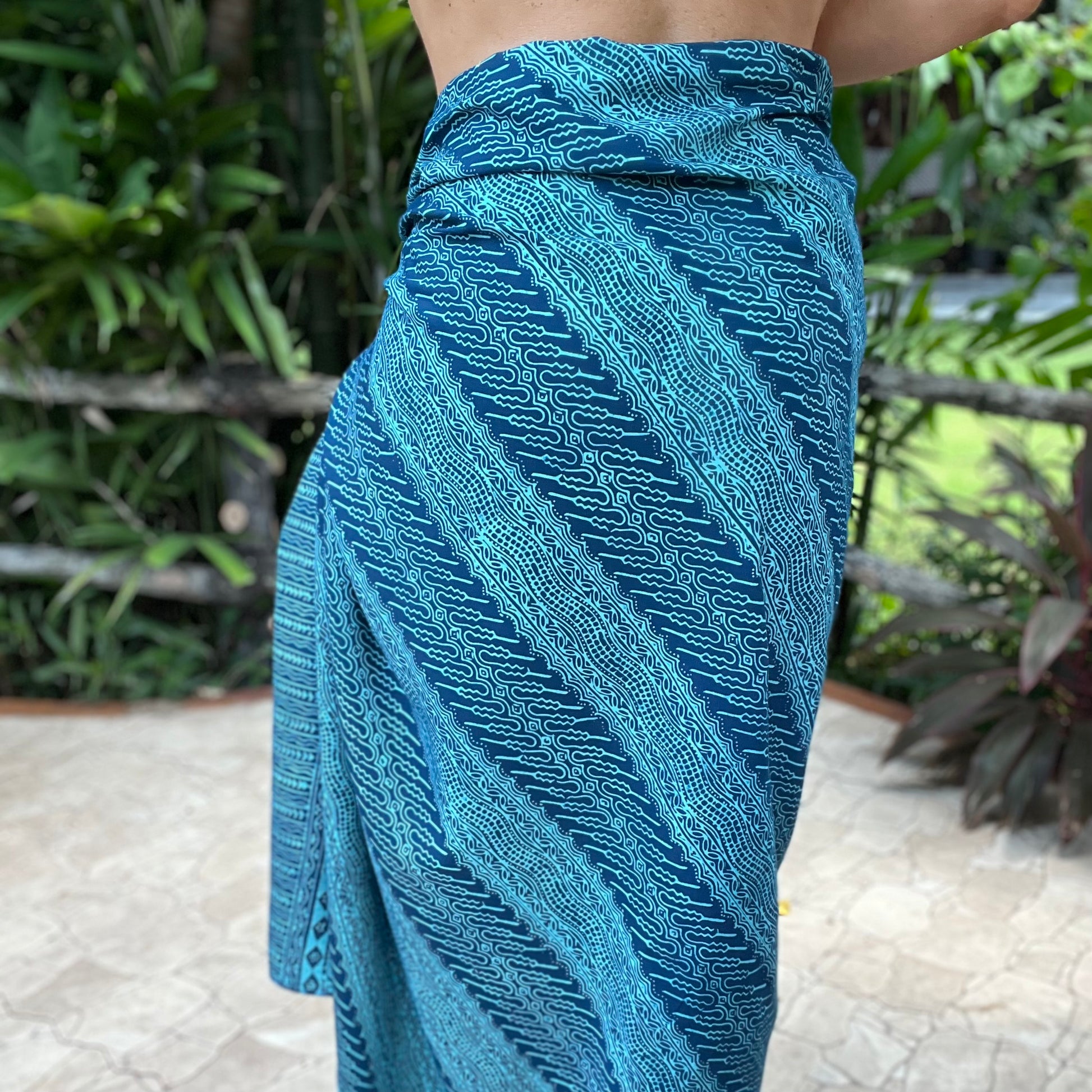 Vivid luxe sarong styled on beach model wearing sarong hut design