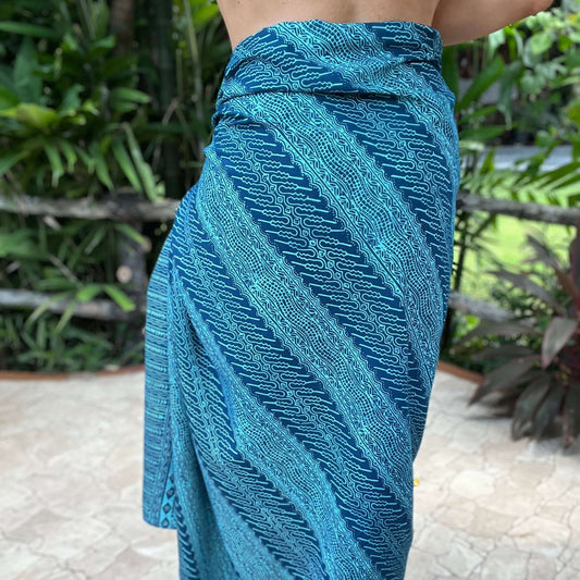 Vivid luxe sarong styled on beach model wearing sarong hut design